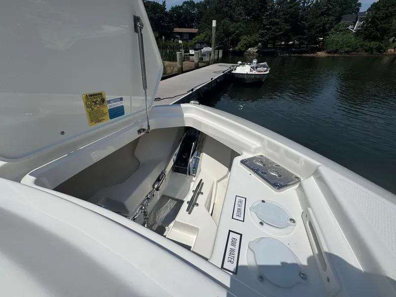 Slide: The Image of 2026 Pursuit DC 306 boat with open storage compartment, docked by a serene waterfront. - 40