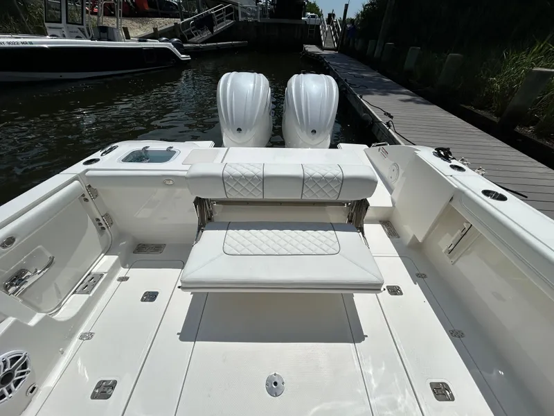 Slide: The Image of 2026 Pursuit DC 306 boat with dual engines, docked at a marina. - 9