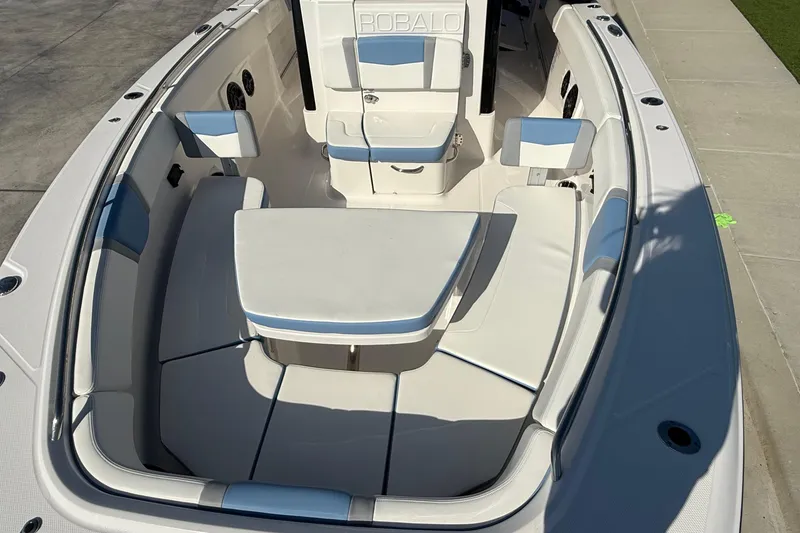 Slide: The Image of 2025 Robalo R300 Center Console boat interior with cushioned seating and table. - 12