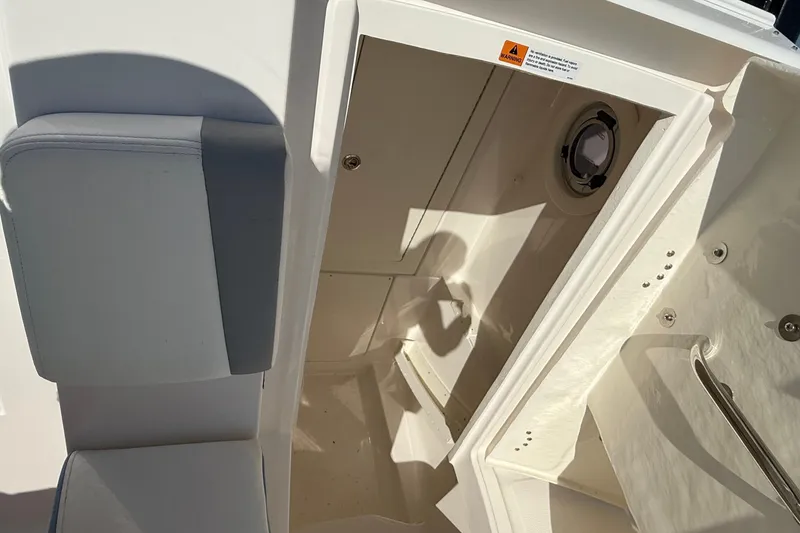 Slide: The Image of 2025 Robalo R300 Center Console interior cabin with seating and porthole. - 13