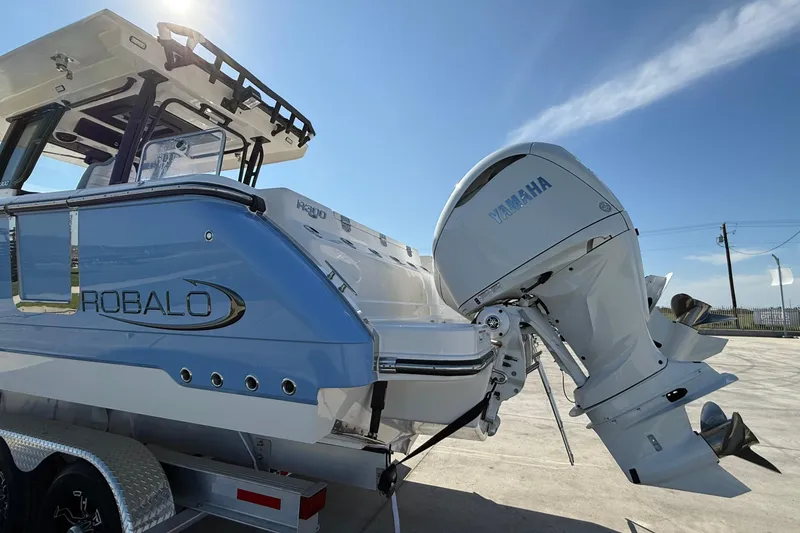 Slide: The Image of 2025 Robalo R300 Center Console boat with Yamaha outboard motor, parked on a trailer. - 21