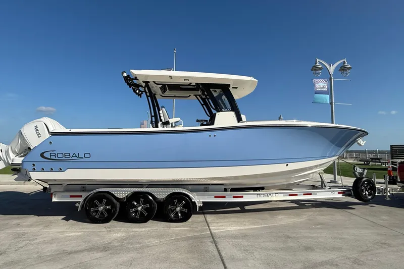 Slide: The Image of 2025 Robalo R300 Center Console boat on trailer, side view, clear sky background. - 6