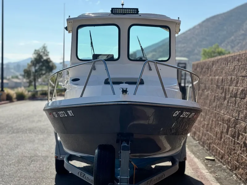 Slide: The Image of 2020 Arima Sea Chaser 19 Yellowtail Edition boat on trailer, parked near a brick wall. - 2