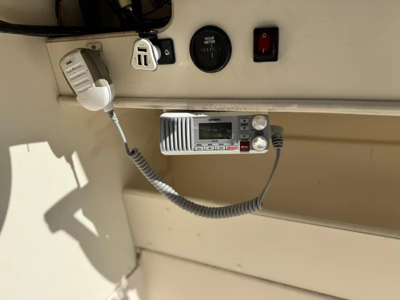 Slide: The Image of Boat dashboard with radio, USB ports, and hour meter on Arima Sea Chaser 19 Yellowtail Edition. - 22