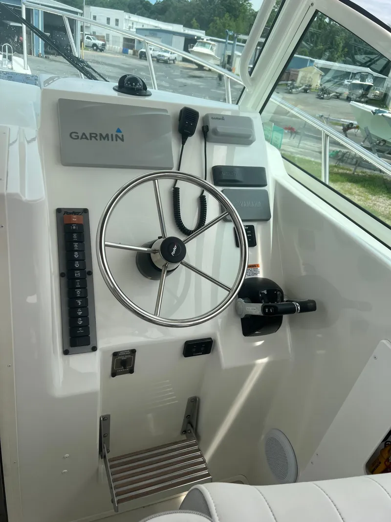 Slide: The Image of 2021 Parker 2510 XL Walkaround boat helm with Garmin navigation system and steering wheel. - 10