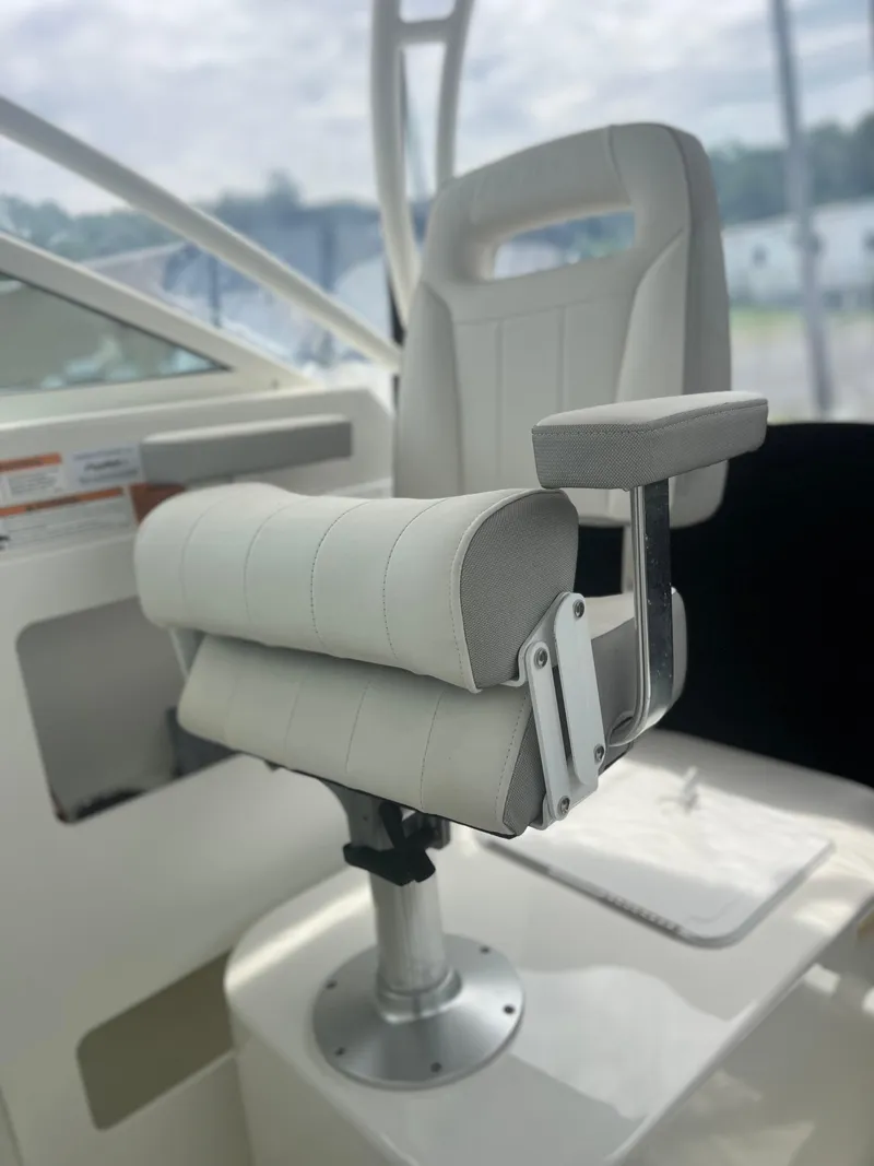 Slide: The Image of Captain's chair on 2021 Parker 2510 XL Walkaround boat, featuring white cushioned seating. - 16