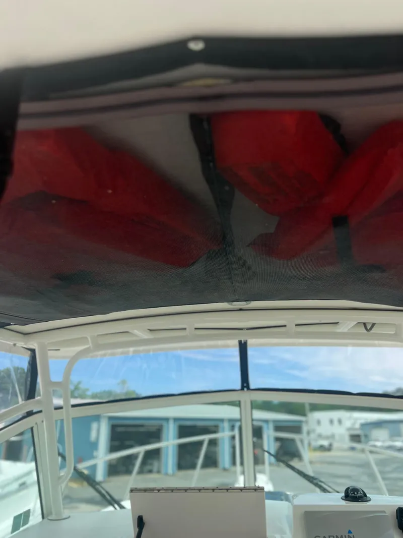 Slide: The Image of 2021 Parker 2510 XL Walkaround boat interior with red life jackets stored overhead. - 17