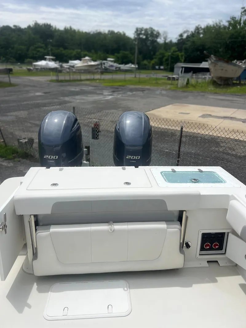 Slide: The Image of 2021 Parker 2510 XL Walkaround boat with dual 200 horsepower engines, docked outdoors. - 18