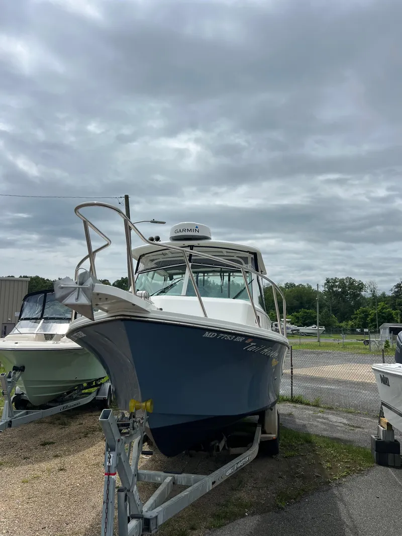 Slide: The Image of 2021 Parker 2510 XL Walkaround boat on trailer under cloudy sky. - 2