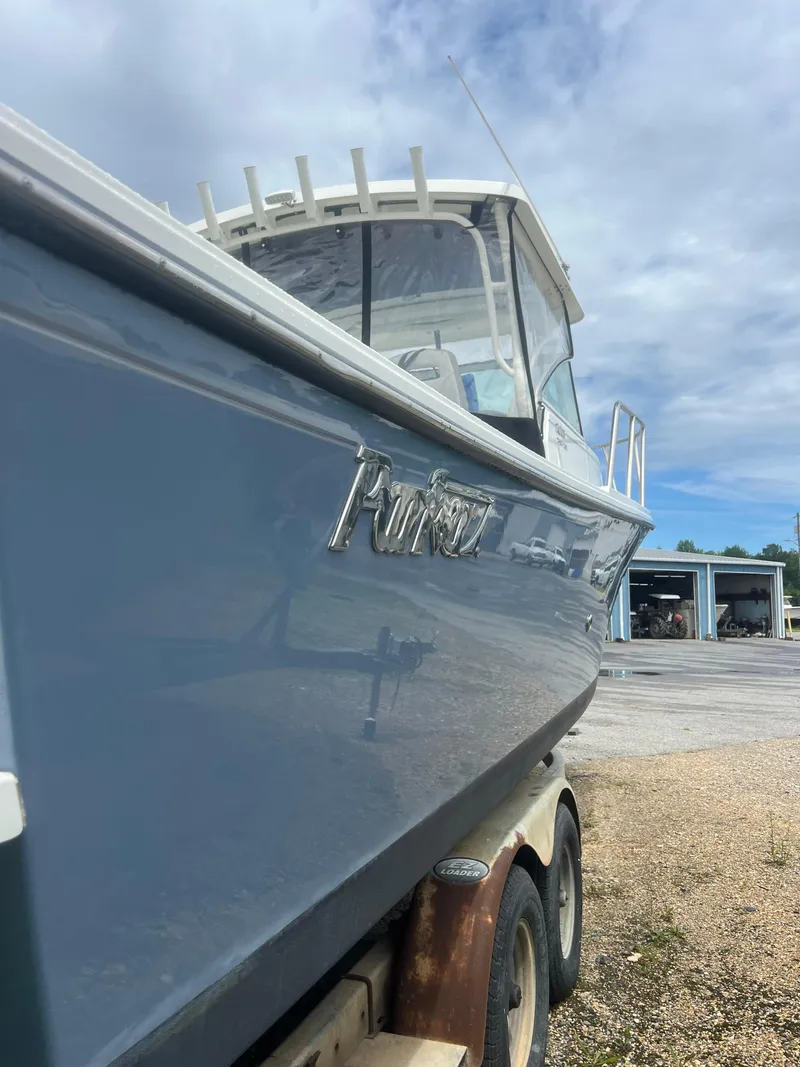 Slide: The Image of 2021 Parker 2510 XL Walkaround boat on trailer, side view under cloudy sky. - 5