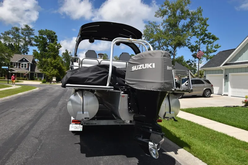 Slide: The Image of 2023 Bentley Pontoons 250 Elite Swingback Dual Captain with Suzuki engine on a residential street. - 2