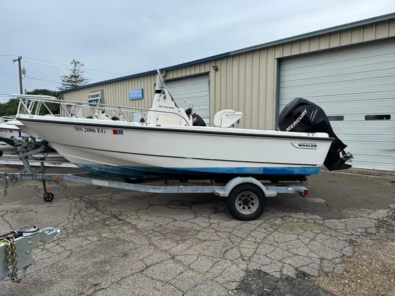 Slide: The Image of 2006 Boston Whaler 190 Outrage boat on trailer, parked outside a garage. - 4