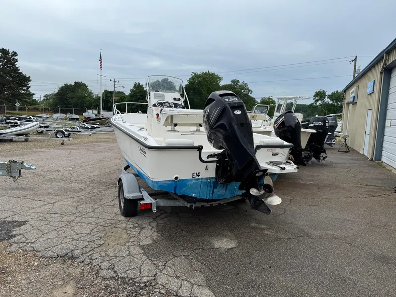 Slide: The Image of 2006 Boston Whaler 190 Outrage boat on trailer, parked outdoors near other boats. - 5