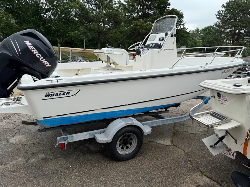 Slide: The Image of 2006 Boston Whaler 190 Outrage boat on trailer with Mercury engine, parked outdoors. - 8