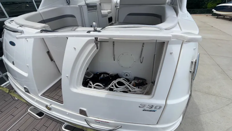 Slide: The Image of 2007 Chaparral Signature 330 boat with open storage compartment and visible ropes. - 14