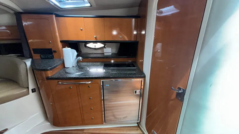 Slide: The Image of 2007 Chaparral Signature 330 yacht interior kitchen with wood cabinets and modern appliances. - 19