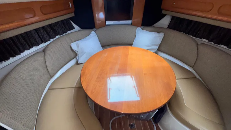 Slide: The Image of 2007 Chaparral Signature 330 cabin with round table, cushioned seating, and TV. - 24