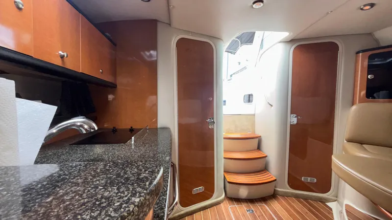 Slide: The Image of 2007 Chaparral Signature 330 interior with wood cabinetry, granite countertop, and curved steps. - 33