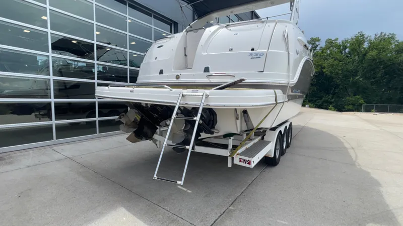 Slide: The Image of 2007 Chaparral Signature 330 boat on trailer, rear view, parked near glass building. - 5