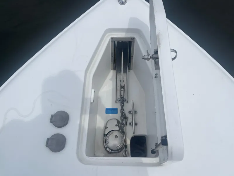 Slide: The Image of Anchor compartment of 2016 Sea Hunt Gamefish 27 boat, open with visible chain and mechanism. - 10