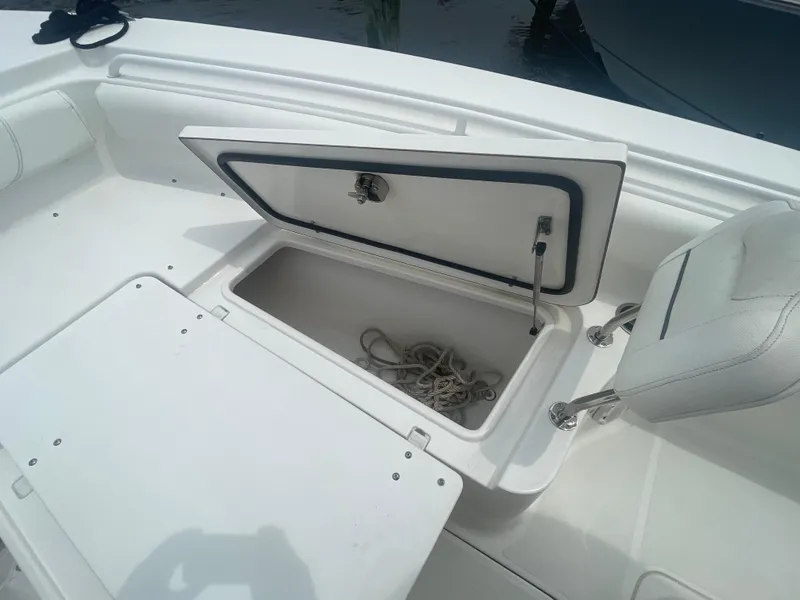 Slide: The Image of 2016 Sea Hunt Gamefish 27 boat storage compartment with open hatch and rope inside. - 16