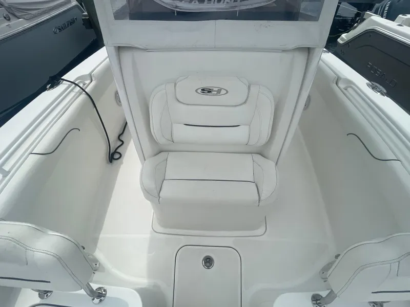 Slide: The Image of 2016 Sea Hunt Gamefish 27 boat interior with white seating and storage compartments. - 18