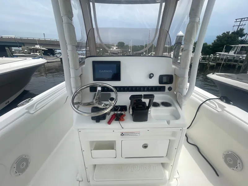 Slide: The Image of 2016 Sea Hunt Gamefish 27 boat console with Garmin navigation system and steering wheel. - 21