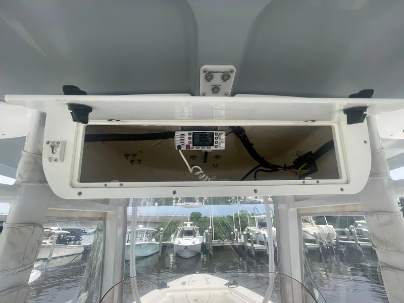 Slide: The Image of 2016 Sea Hunt Gamefish 27 boat console with open storage compartment and marine radio. - 35