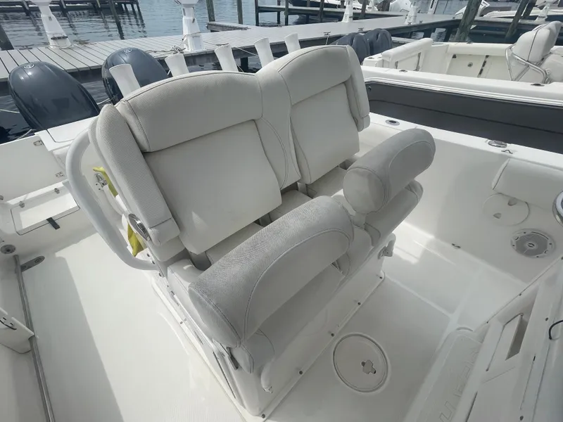 Slide: The Image of 2016 Sea Hunt Gamefish 27 boat interior with cushioned seating and dual outboard motors. - 37