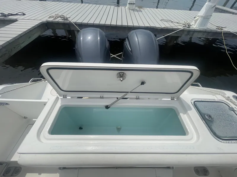 Slide: The Image of 2016 Sea Hunt Gamefish 27 boat with open storage compartment at dock. - 44