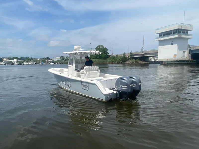 Slide: The Image of 2016 Sea Hunt Gamefish 27 boat with dual Yamaha engines on a calm river. - 7