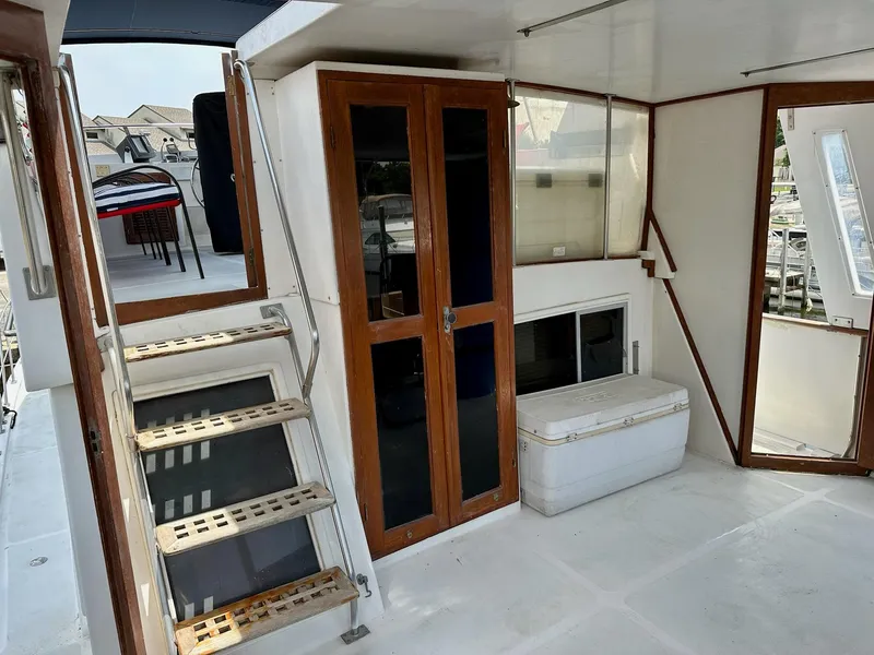 Slide: The Image of 1987 Jefferson Sundeck yacht interior with wooden doors, stairs, and a white cooler. - 11