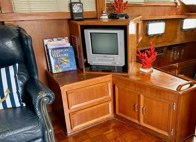 Slide: The Image of 1987 Jefferson Sundeck interior with vintage TV, books, and nautical decor. - 12