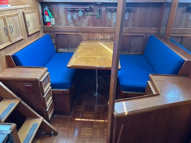 Slide: The Image of 1987 Jefferson Sundeck interior with blue seating, wooden table, and storage cabinets. - 13