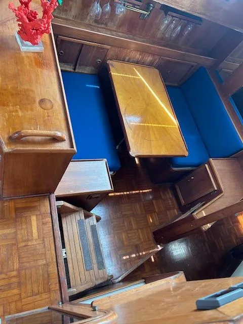 Slide: The Image of 1987 Jefferson Sundeck interior with wooden dining area and blue cushioned seating. - 14