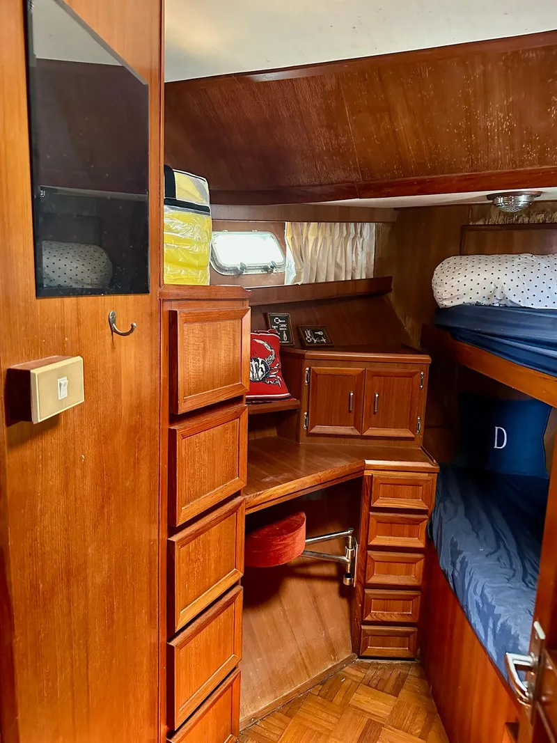 Slide: The Image of 1987 Jefferson Sundeck yacht interior with wooden cabinetry and cozy sleeping area. - 20