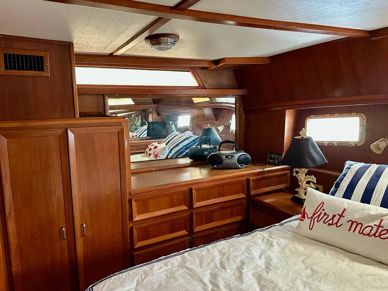 Slide: The Image of 1987 Jefferson Sundeck yacht cabin with wooden interior, striped bedding, and nautical decor. - 26