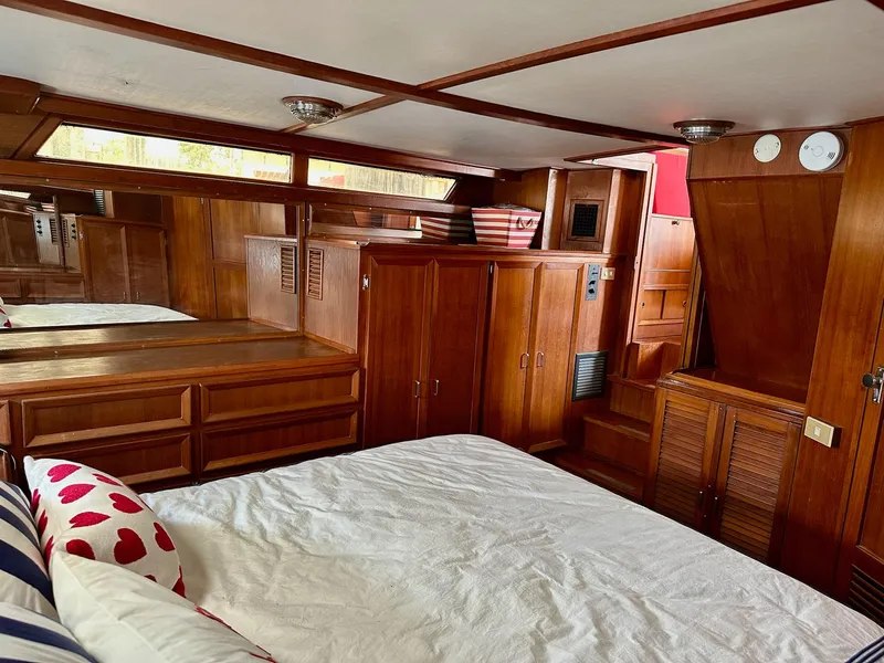 Slide: The Image of 1987 Jefferson Sundeck yacht interior with wooden cabinetry and cozy bedding. - 28
