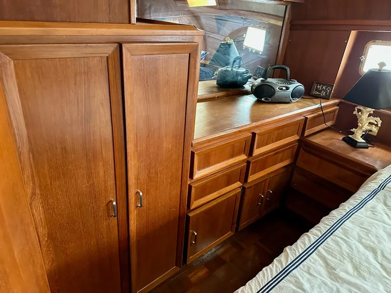 Slide: The Image of 1987 Jefferson Sundeck interior with wooden cabinets, drawers, and a decorative lamp. - 30