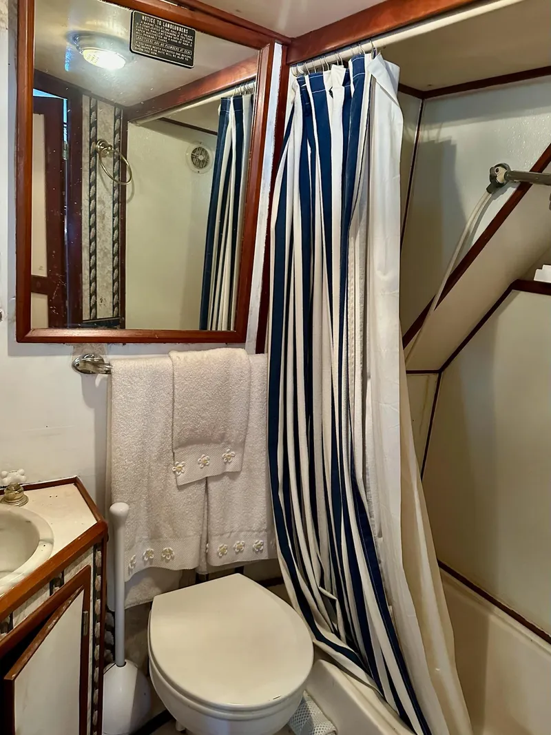 Slide: The Image of Compact bathroom in 1987 Jefferson Sundeck boat with striped shower curtain. - 31