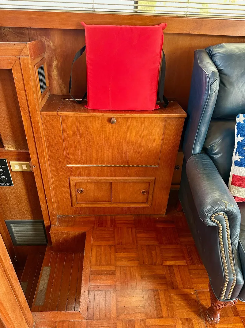 Slide: The Image of 1987 Jefferson Sundeck interior with wooden cabinet, red cushion, and leather chair. - 34