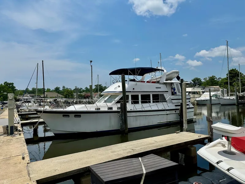 Slide: The Image of 1987 Jefferson Sundeck yacht docked at marina under blue sky. - 4