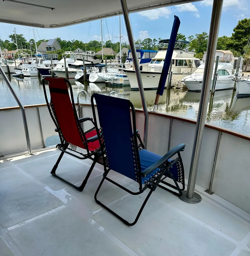 Slide: The Image of Two deck chairs on a 1987 Jefferson Sundeck yacht overlooking a marina. - 6