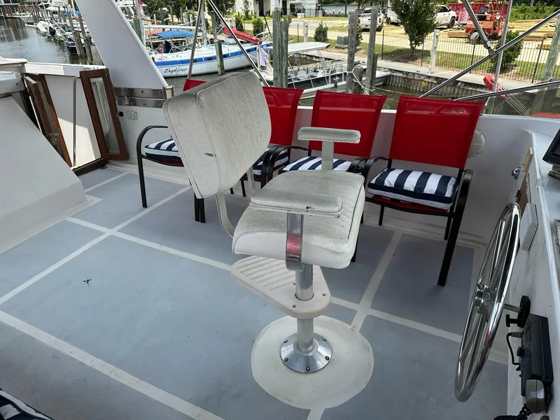 Slide: The Image of 1987 Jefferson Sundeck boat helm with white captain's chair and red seating. - 7