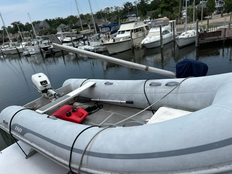 Slide: The Image of Inflatable boat on 1987 Jefferson Sundeck, docked at marina with yachts in background. - 8