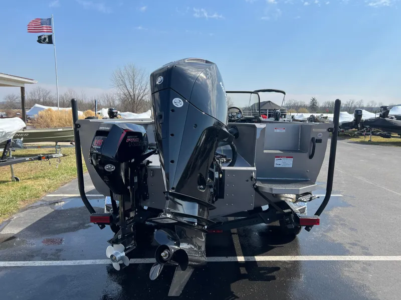 Slide: The Image of 2025 Crestliner 2050 Authority boat with dual outboard motors in a parking lot. - 2