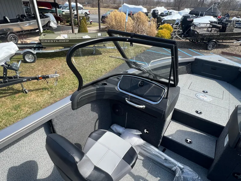 Slide: The Image of 2025 Crestliner 2050 Authority boat interior with seating and console, displayed outdoors. - 21