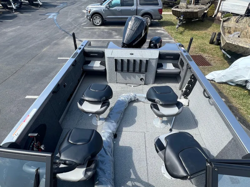 Slide: The Image of 2025 Crestliner 2050 Authority boat interior with seating and motor, parked outdoors. - 22