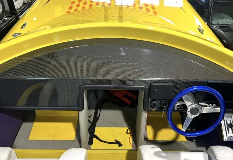 Slide: The Image of Yellow Predator C30 boat interior with blue steering wheel, carbon fiber dashboard, and white seats. - 10
