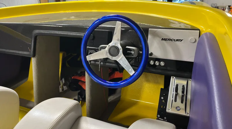 Slide: The Image of Interior of a 2018 Predator C30 boat with blue steering wheel and Mercury controls. - 12